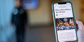 Woman holding cell phone with article Where Police Reform Has Worked, New York Times, June 11, 2020 by David Leonhardt